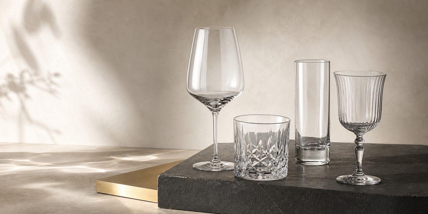 A contemporary assortment of clear glassware on stone and metal surfaces